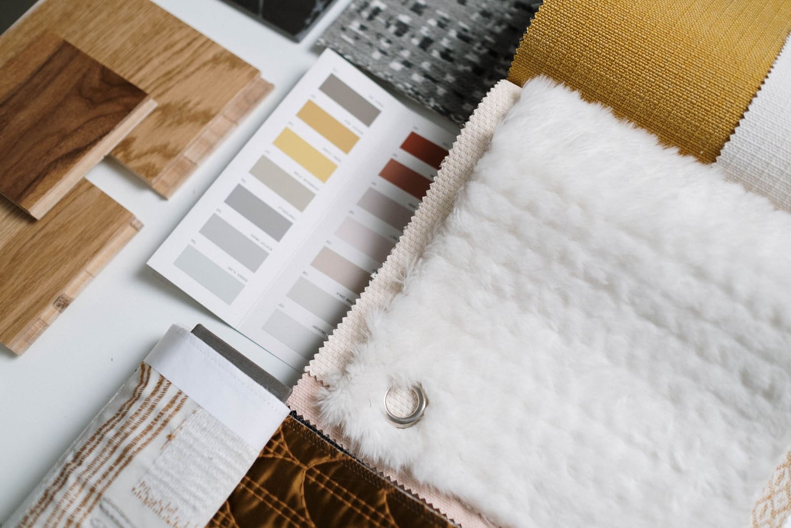 Timber samples, a paint colour card and textile swatches laid out together